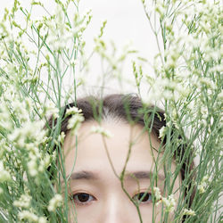 Close-up portrait of young woman amidst flowers