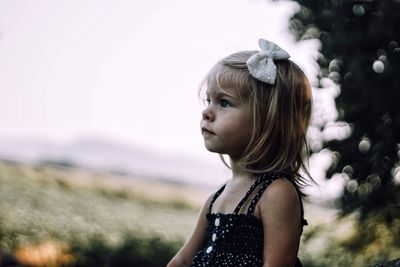 Close-up of girl standing against sky