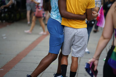 Low section of two young african american gay men dancinf on street