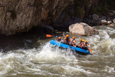 High angle view of people on rock by river