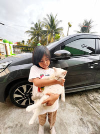 Side view of woman sitting on car