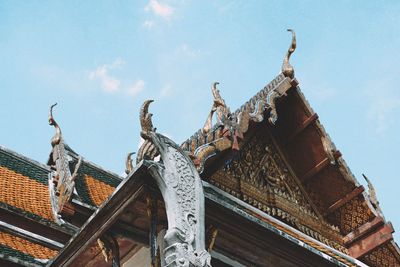 Low angle view of statues on building against sky