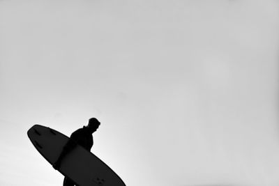 Low angle view of silhouette airplane against clear sky