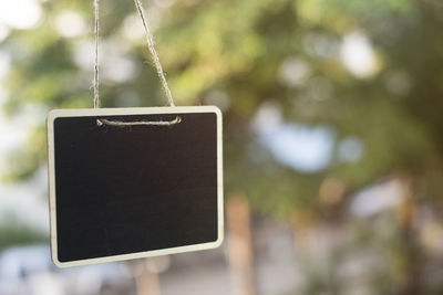 Close-up of smart phone hanging outdoors