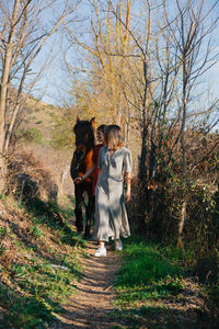 Rear view of women walking by plants