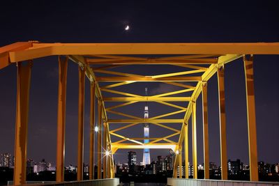 Illuminated suspension bridge against sky at night