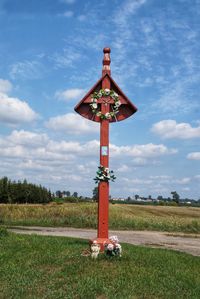 Traditional windmill on field against sky