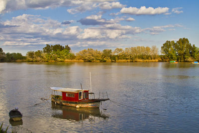 Boat floating on river against sky