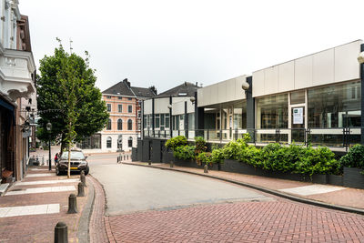 Houses by street against sky in city