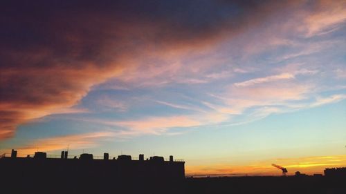 Silhouette cityscape against sky during sunset