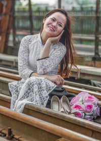 Portrait of a smiling young woman sitting outdoors