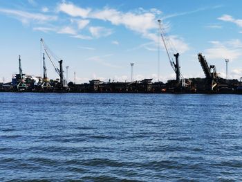 Commercial dock by sea against sky