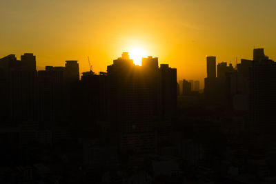 Silhouette buildings against sky during sunset