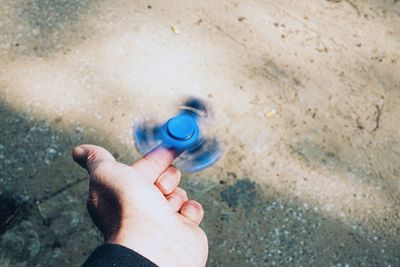 Spinning fidget gadget on male finger outdoors