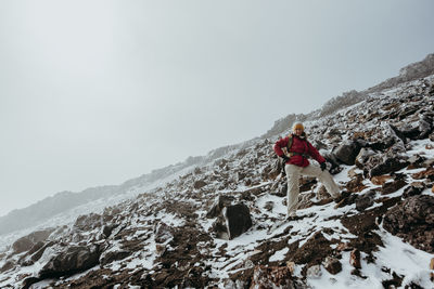 Person on snow covered mountain against sky