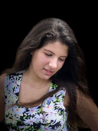 Portrait of beautiful young woman against black background