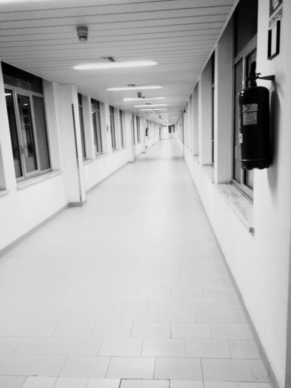 architecture, built structure, indoors, the way forward, corridor, diminishing perspective, empty, illuminated, lighting equipment, ceiling, flooring, tiled floor, building, absence, narrow, in a row, building exterior, vanishing point, no people, door