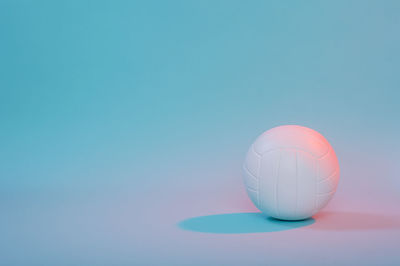 Close-up of volleyball over colored background