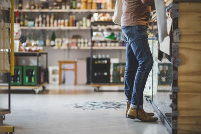 Low section of customer standing at checkout counter in deli