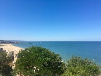 Scenic view of sea and coastline against clear blue sky 