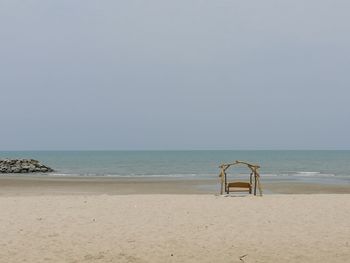 Lifeguard chair on beach against clear sky