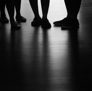 Low section of women standing on hardwood floor