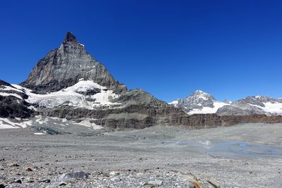 Scenic view of snowcapped mountains against clear blue sky