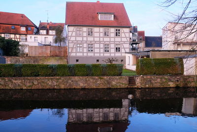 Canal by buildings against sky