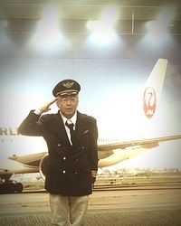 Portrait of man wearing sunglasses standing by airplane