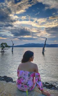 Rear view of woman looking at sea against sky