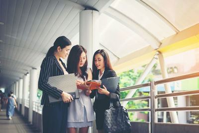 Businesswomen discussing while standing on footbridge