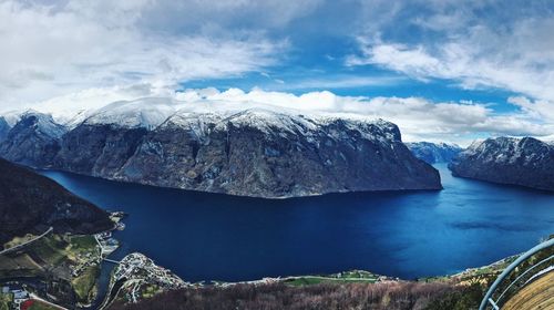 Scenic view of mountain by lake against cloudy sky