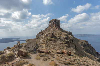 Rock formation by sea against sky