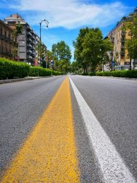 Scenic view of city road against cloudy sky