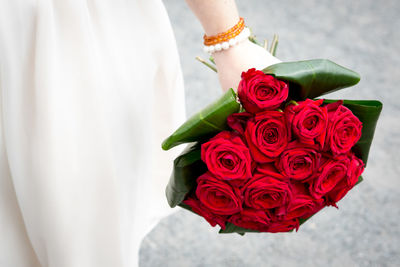 Close-up of hand holding red rose