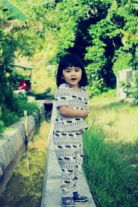 Portrait of smiling girl with flowers on grass