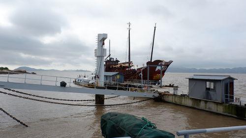 Commercial dock by sea against sky