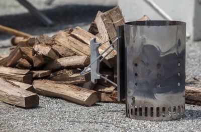 Close-up of camping stove by logs on field