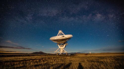 Traditional windmill on field against sky at night