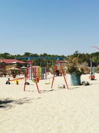Deck chairs on beach against clear sky