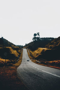 Road by mountain against clear sky