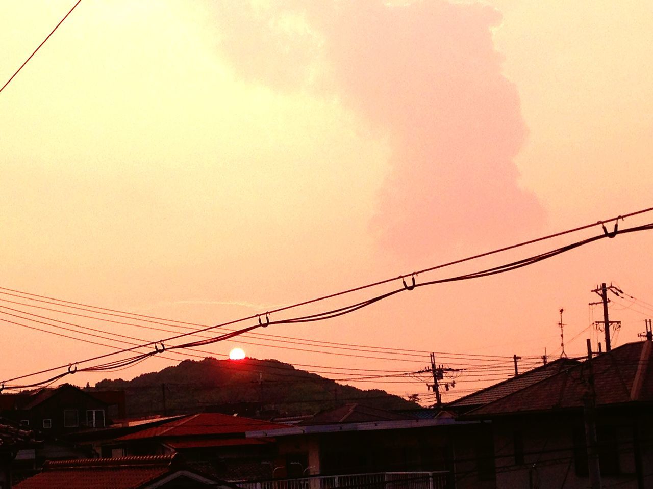 sunset, architecture, built structure, building exterior, power line, orange color, sky, electricity pylon, low angle view, cable, connection, silhouette, electricity, power supply, house, roof, residential structure, sun, residential building, cloud - sky