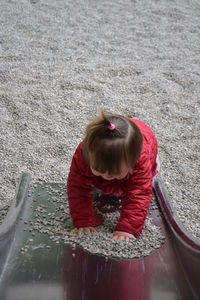 High angle view of girl playing with pebbles on slide