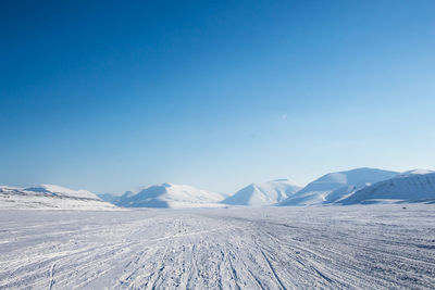 Scenic view of snowcapped mountains against clear blue sky
