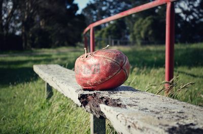 Close-up of old wooden bench at a football field
