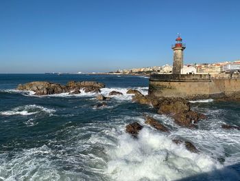 Scenic view of sea and buildings against clear sky