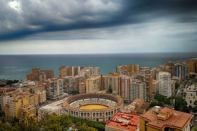 High angle view of buildings by sea against sky