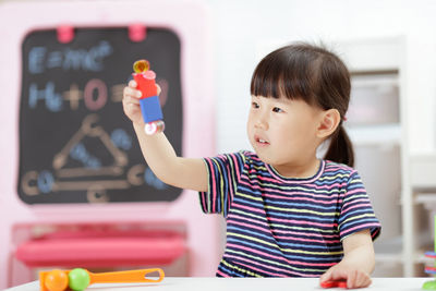 Young girl playing science experiment at home 