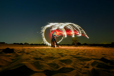 Light painting on beach against sky at night