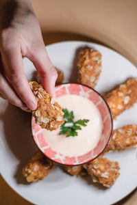 Close-up of hand holding food served in plate